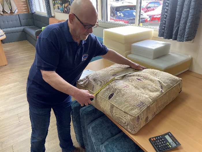 Measurements are taken of a customer's cushion prior to refilling